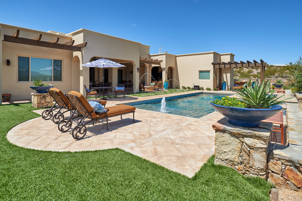 Photo of a mid-sized backyard rectangular pool in Other with a water feature and natural stone pavers.