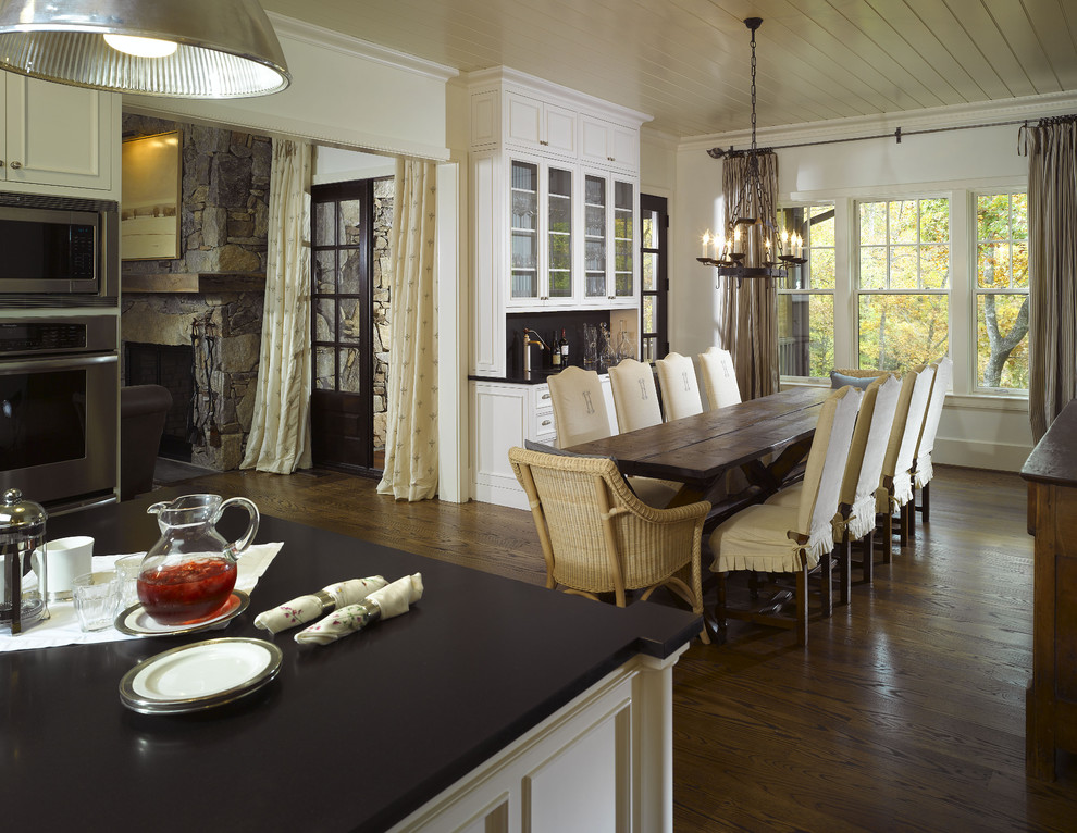 Design ideas for a traditional kitchen/dining combo in Atlanta with white walls and dark hardwood floors.