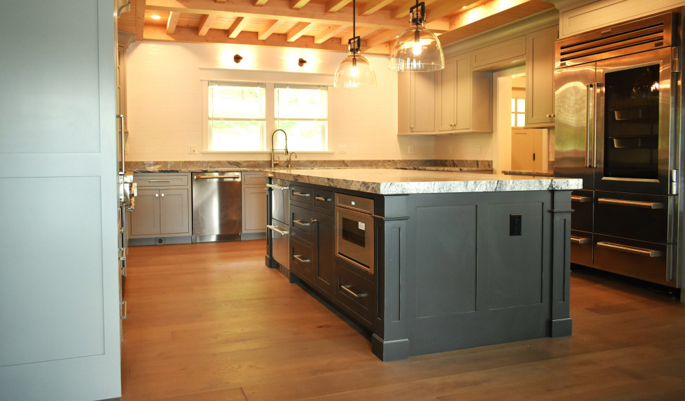 This is an example of a traditional eat-in kitchen with recessed-panel cabinets, grey cabinets and with island.