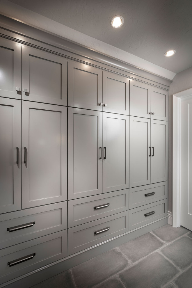 Photo of a large modern gender-neutral storage and wardrobe in Other with vaulted, porcelain floors and grey floor.