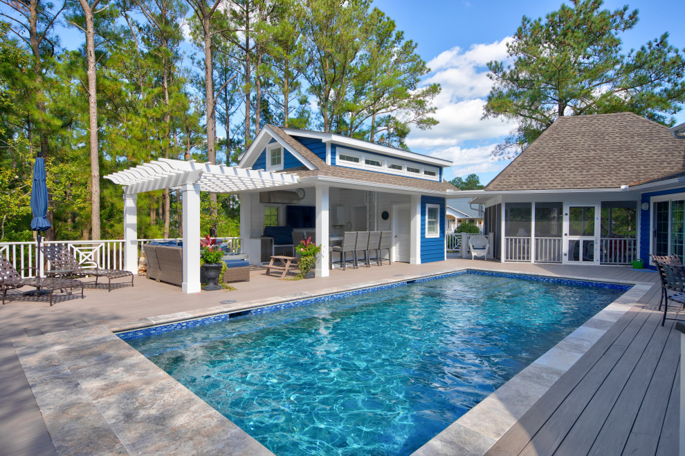 This is an example of a mid-sized traditional backyard rectangular pool in Other with decking.