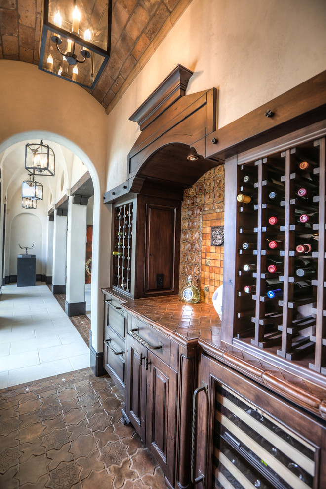Design ideas for a mid-sized mediterranean wine cellar in Houston with ceramic floors, storage racks and brown floor.