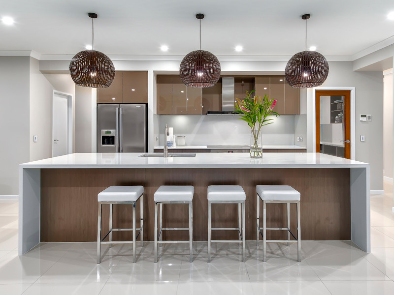 Photo of a mid-sized contemporary single-wall open plan kitchen in Brisbane with an undermount sink, brown cabinets, solid surface benchtops, grey splashback, glass sheet splashback, stainless steel appliances, ceramic floors, with island and flat-panel cabinets.