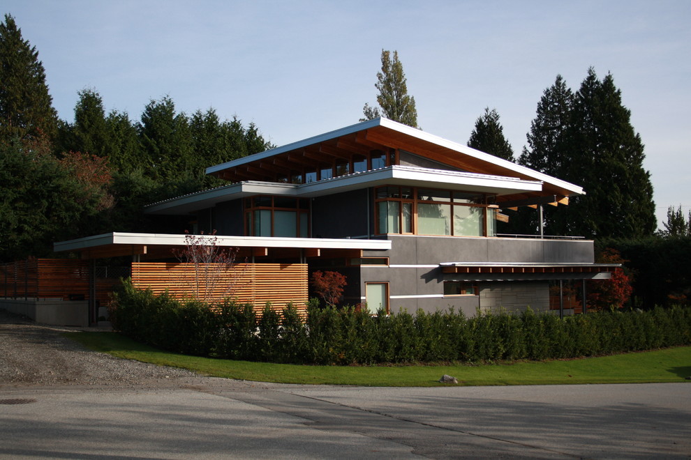 Inspiration for a large contemporary two-storey stucco grey exterior in Vancouver with a flat roof.