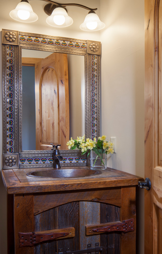 Country powder room in Denver with furniture-like cabinets, dark wood cabinets, a drop-in sink, wood benchtops, brown benchtops and beige walls.