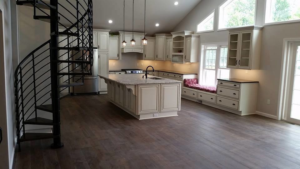 Inspiration for a large transitional l-shaped medium tone wood floor and brown floor open concept kitchen remodel with an undermount sink, raised-panel cabinets, white cabinets, granite countertops, stainless steel appliances, an island and beige countertops