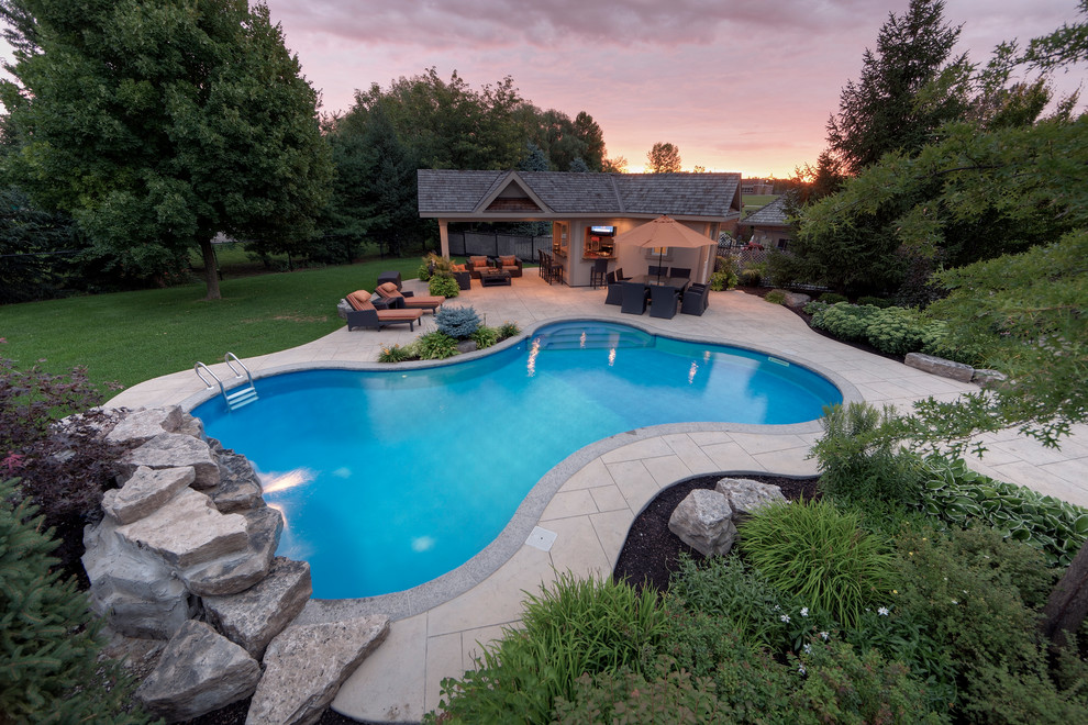 Design ideas for a contemporary backyard custom-shaped pool in Toronto with a pool house.