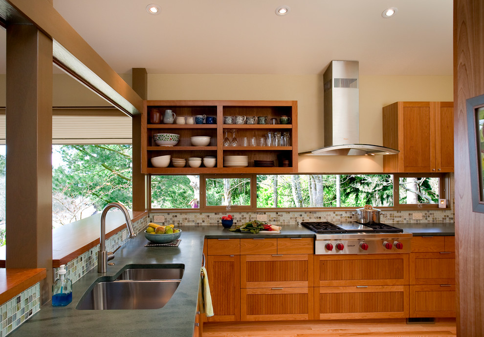 Midcentury u-shaped separate kitchen in Seattle with recessed-panel cabinets, medium wood cabinets, wood benchtops, multi-coloured splashback, mosaic tile splashback and stainless steel appliances.