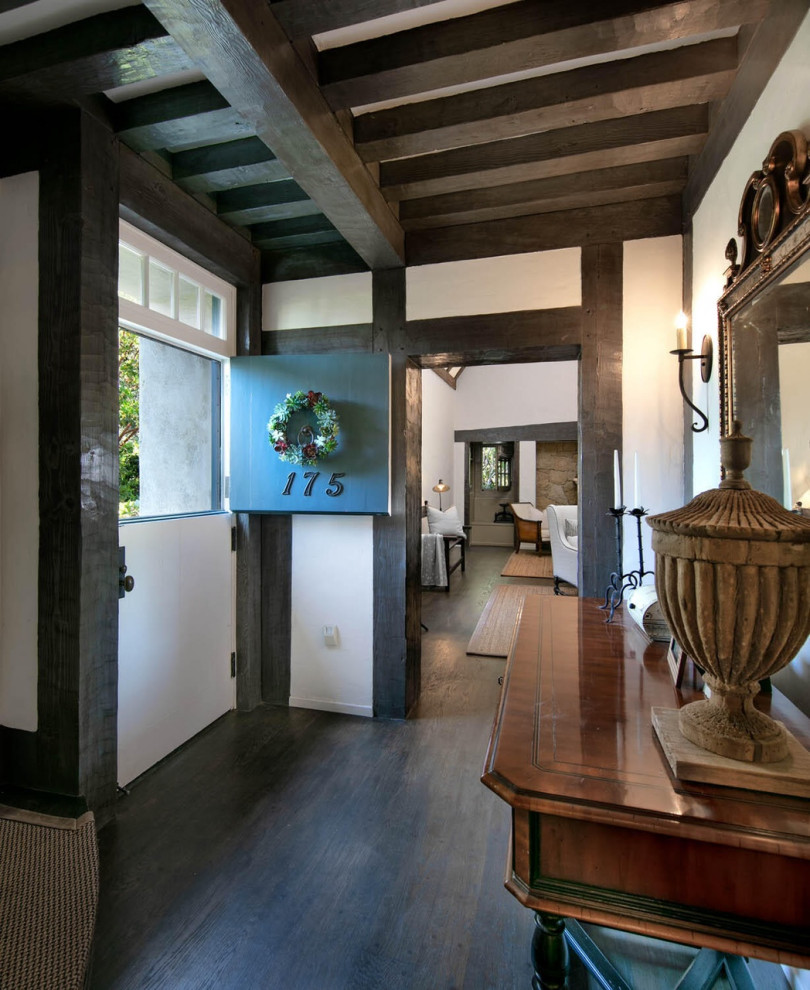 サンタバーバラにある高級な小さなシャビーシック調のおしゃれな玄関ラウンジ (白い壁、濃色無垢フローリング、緑のドア、茶色い床、表し梁) の写真