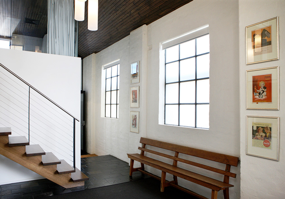 This is an example of a mid-sized modern hallway in Melbourne with white walls, slate floors and black floor.