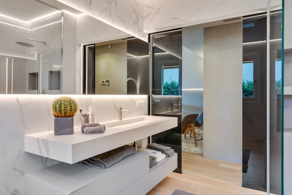This is an example of a large modern master bathroom in Other with flat-panel cabinets, grey cabinets, an open shower, a wall-mount toilet, white tile, porcelain tile, white walls, painted wood floors, a trough sink, white benchtops, an enclosed toilet, a single vanity and a floating vanity.