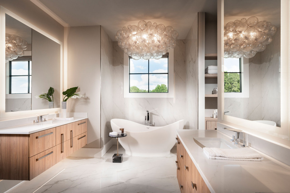 This is an example of a large modern master bathroom in Other with flat-panel cabinets, light wood cabinets, a freestanding tub, an alcove shower, a bidet, white tile, marble, grey walls, marble floors, an undermount sink, engineered quartz benchtops, white floor, a hinged shower door, white benchtops, an enclosed toilet, a double vanity and a floating vanity.