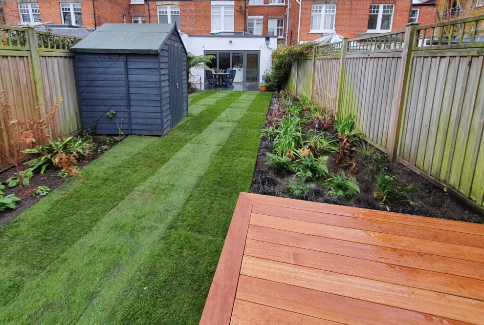 Design ideas for a mid-sized contemporary backyard partial sun garden in London with a vertical garden and decking.