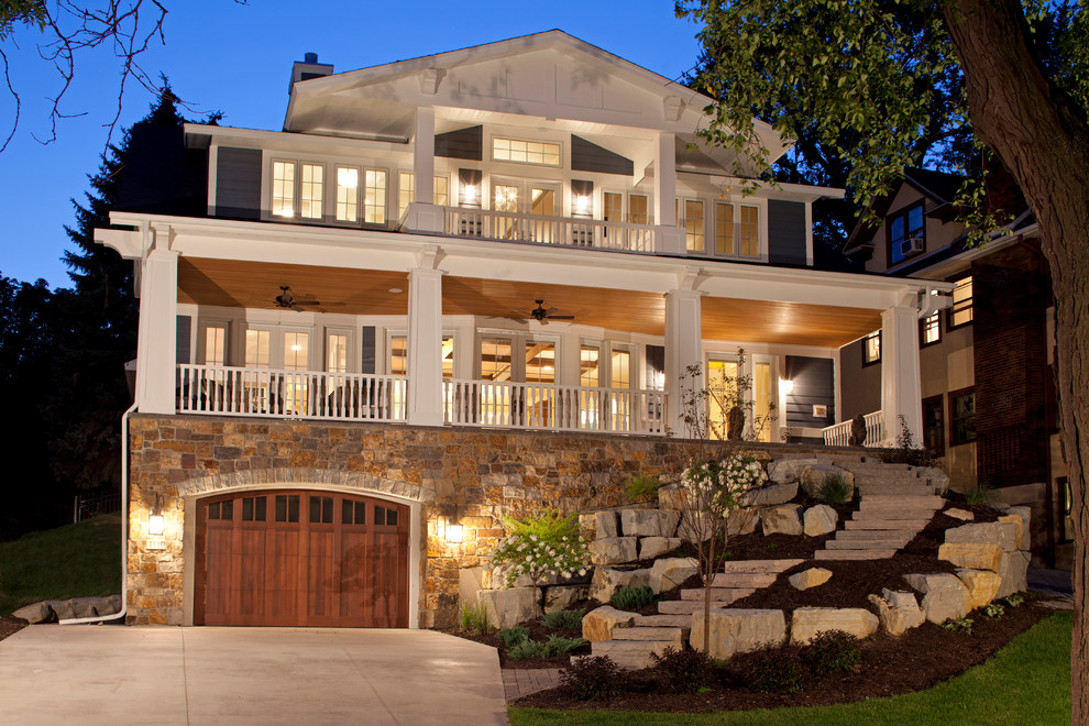 Inspiration for a large traditional two-storey blue exterior in Minneapolis with stone veneer and a gable roof.