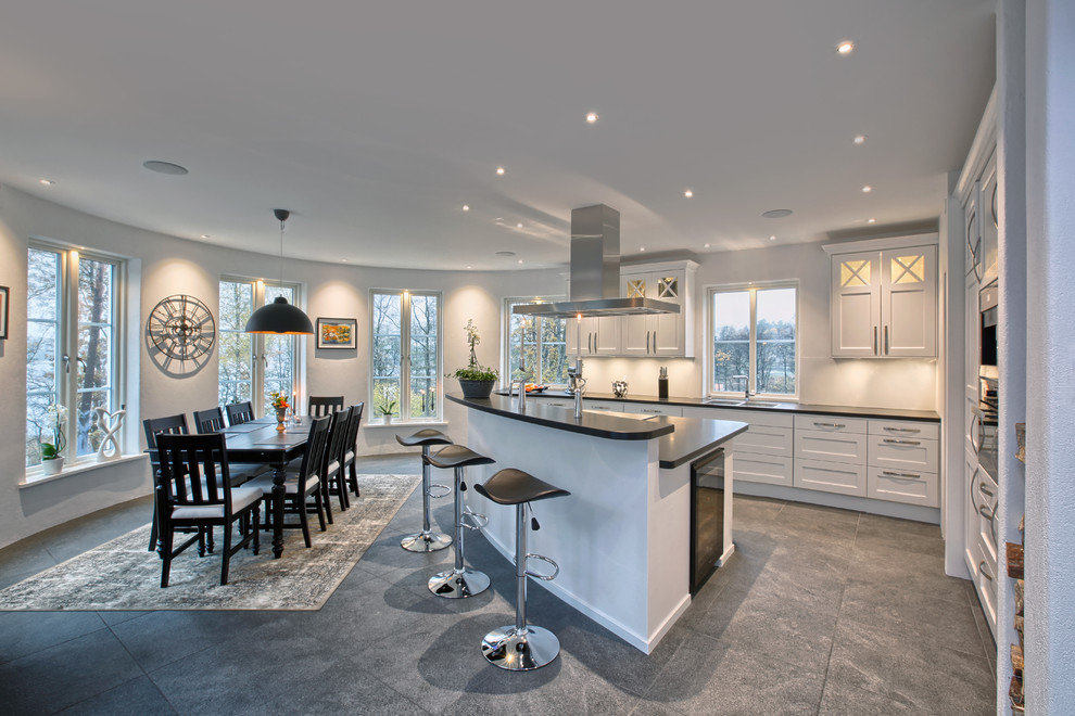 Large contemporary galley eat-in kitchen in Gothenburg with a double-bowl sink, glass-front cabinets, white cabinets, stainless steel appliances, ceramic floors, with island and granite benchtops.