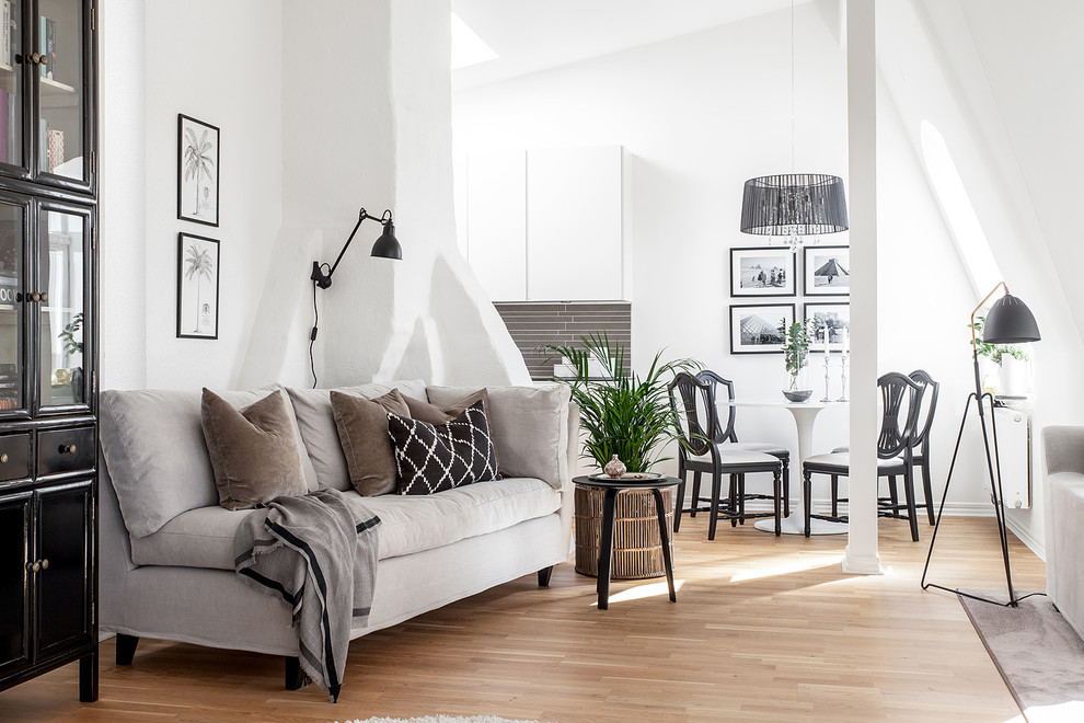 Large scandinavian open concept living room in Gothenburg with white walls, light hardwood floors, no tv and brown floor.