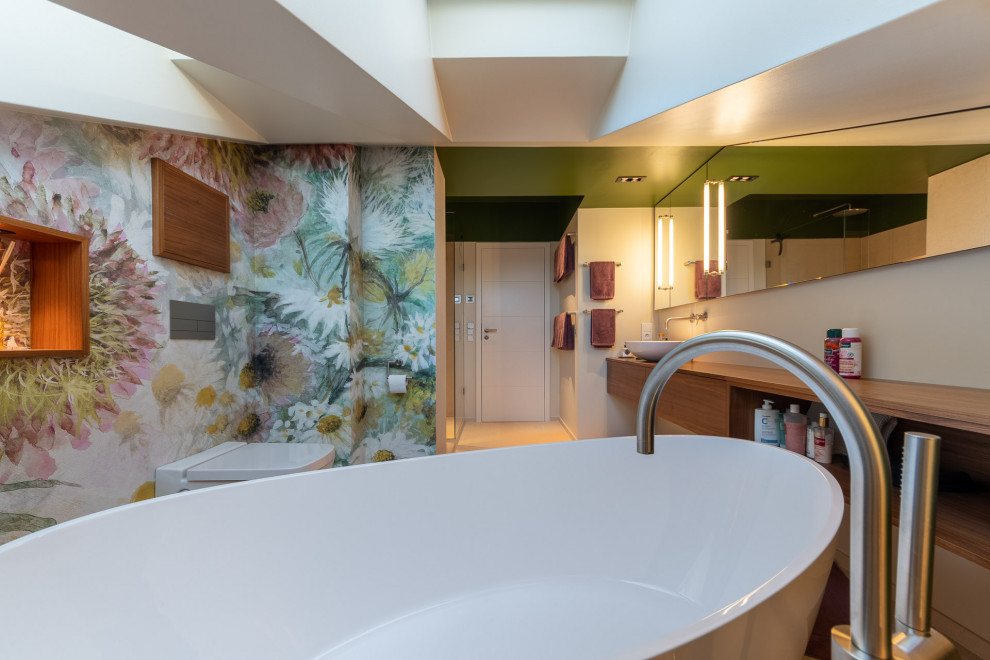Badezimmer En Suite With braunen Schränken, freistehender Badewanne, Eckdusche, beigen Fliesen, Steinplatten, beiger Wandfarbe, Travertin, beigem Boden, Einzelwaschbecken and freistehendem Waschtisch in Munich