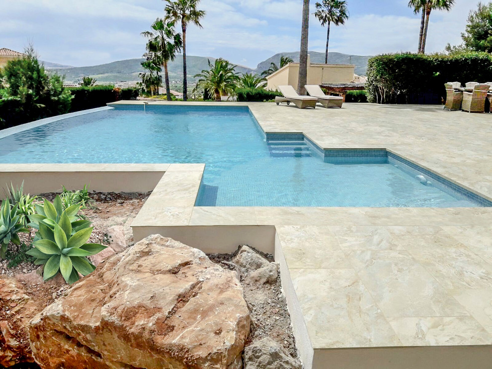 Modelo de piscina alargada clásica renovada grande a medida en patio con suelo de baldosas