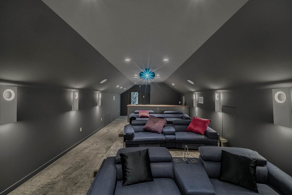 Large contemporary enclosed home theatre in Orlando with black walls, carpet, brown floor and a projector screen.