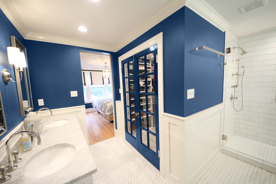 Inspiration for a mid-sized master bathroom in St Louis with recessed-panel cabinets, white cabinets, a corner shower, a one-piece toilet, blue walls, ceramic floors, a drop-in sink, onyx benchtops, white floor, a hinged shower door, white benchtops and a freestanding tub.