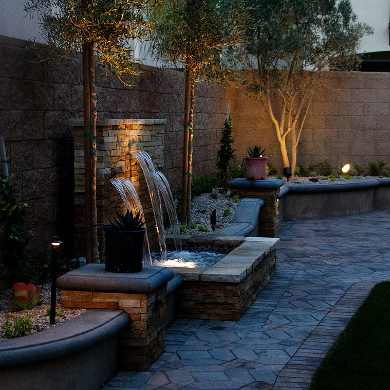 Inspiration for a mid-sized traditional courtyard shaded formal garden in Orange County with a water feature and brick pavers.
