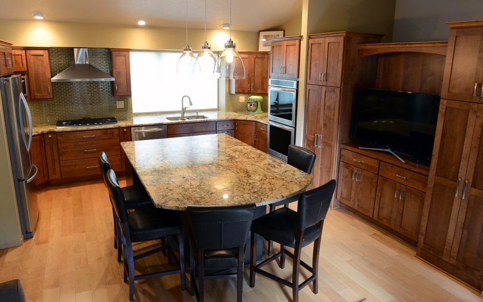 Mid-sized transitional u-shaped light wood floor open concept kitchen photo with an undermount sink, shaker cabinets, medium tone wood cabinets, granite countertops, glass tile backsplash, stainless steel appliances and an island