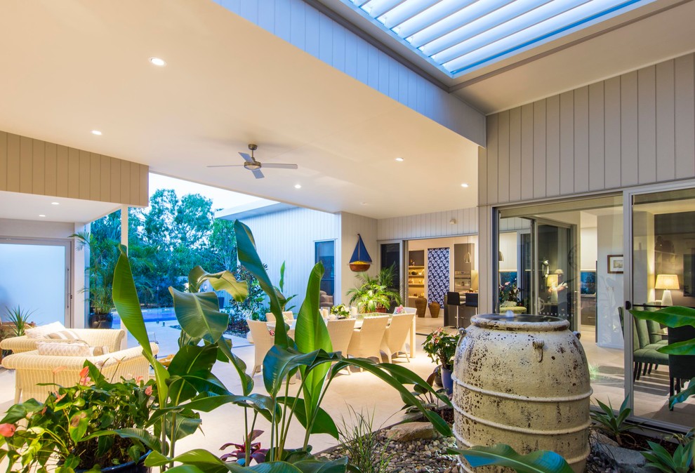 Inspiration for a mid-sized beach style courtyard patio in Brisbane with a water feature and a roof extension.