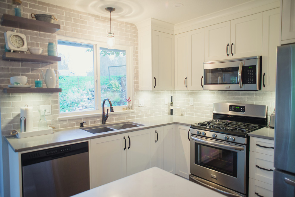 Inspiration for a mid-sized transitional l-shaped open concept kitchen remodel in Vancouver with an undermount sink, shaker cabinets, white cabinets, quartz countertops, gray backsplash, stainless steel appliances and an island