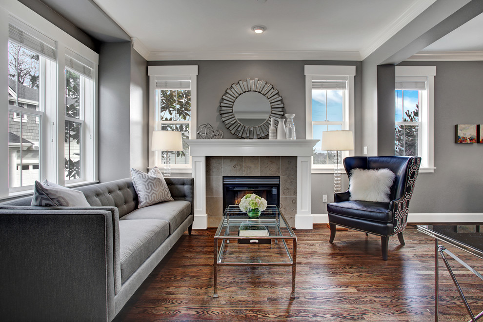 Inspiration for a transitional living room in Seattle with grey walls, dark hardwood floors, a standard fireplace and a tile fireplace surround.