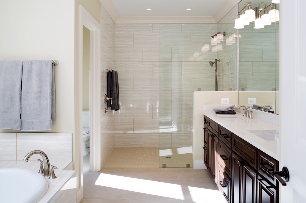 Inspiration for a mid-sized modern master bathroom in DC Metro with an open shower, a drop-in sink, raised-panel cabinets, dark wood cabinets, a drop-in tub, a one-piece toilet, beige tile, ceramic tile, beige walls, ceramic floors, engineered quartz benchtops, beige floor and an open shower.