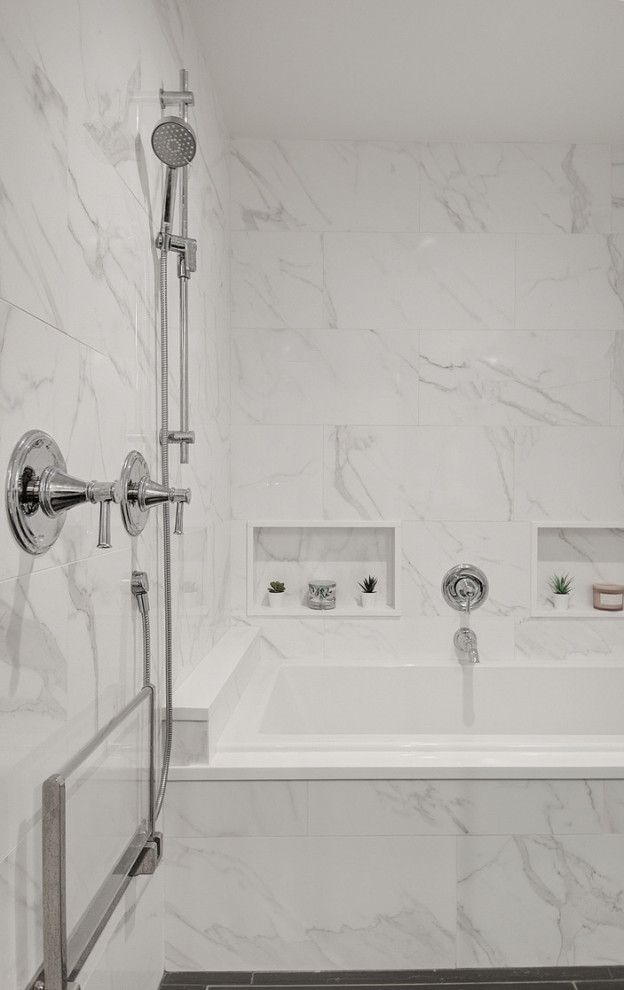Inspiration for a large transitional white tile and porcelain tile porcelain tile, gray floor and single-sink drop-in bathtub remodel with recessed-panel cabinets, white cabinets, a two-piece toilet, gray walls, an undermount sink, quartz countertops, a hinged shower door, gray countertops, a niche and a built-in vanity