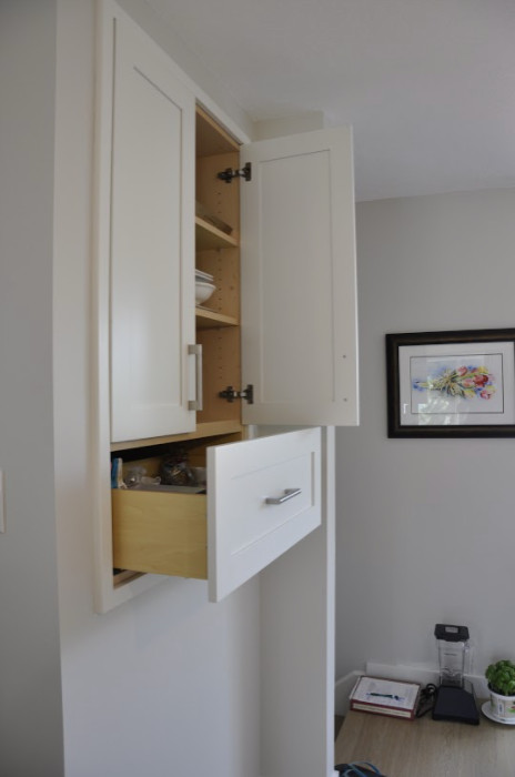 Kitchen pantry - small modern single-wall kitchen pantry idea in Calgary with recessed-panel cabinets, white cabinets and an island