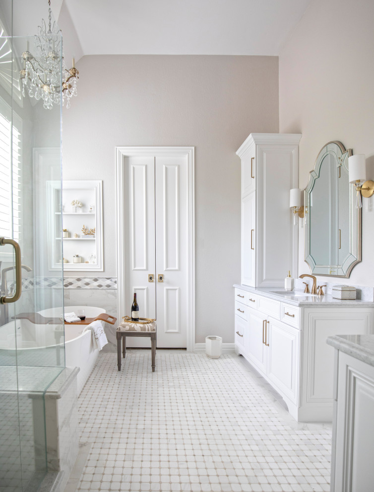 Design ideas for a mid-sized traditional master bathroom in Dallas with raised-panel cabinets, white cabinets, a freestanding tub, a corner shower, a two-piece toilet, white tile, porcelain tile, grey walls, mosaic tile floors, an undermount sink, engineered quartz benchtops, white floor, a hinged shower door, grey benchtops, a shower seat, a double vanity, a built-in vanity and vaulted.