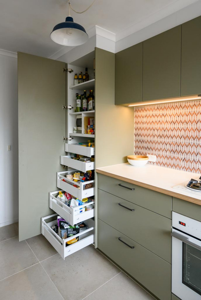 Small danish l-shaped ceramic tile and beige floor enclosed kitchen photo in Melbourne with a double-bowl sink, flat-panel cabinets, green cabinets, laminate countertops, multicolored backsplash, ceramic backsplash, white appliances and white countertops