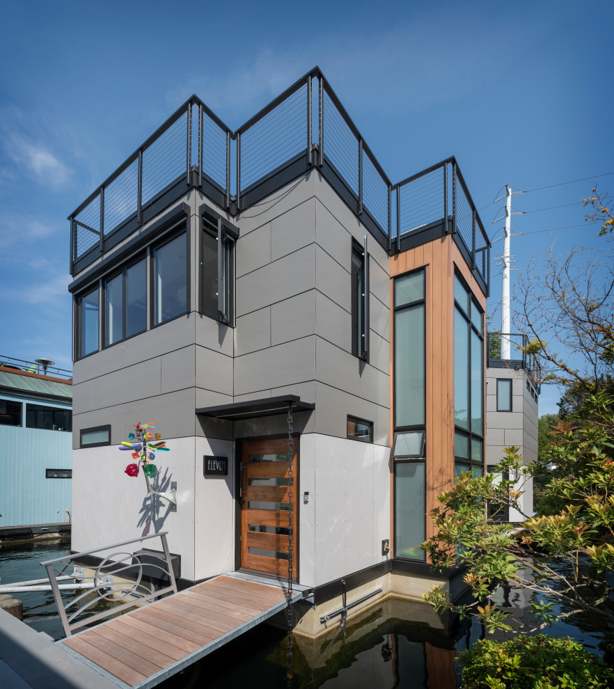 Photo of a contemporary multi-coloured house exterior in Seattle with mixed siding and a flat roof.