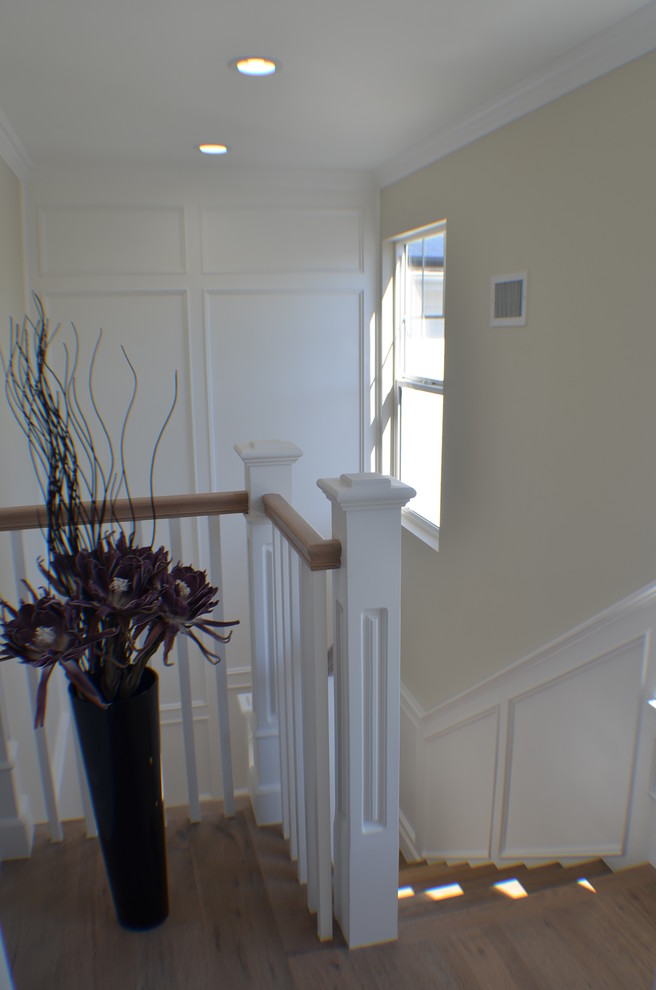 This is an example of a small traditional wood l-shaped staircase in Los Angeles with wood risers and wood railing.