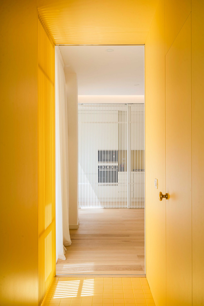 Foto di un piccolo ingresso o corridoio design con pareti gialle, pavimento in gres porcellanato, pavimento giallo, soffitto ribassato e boiserie