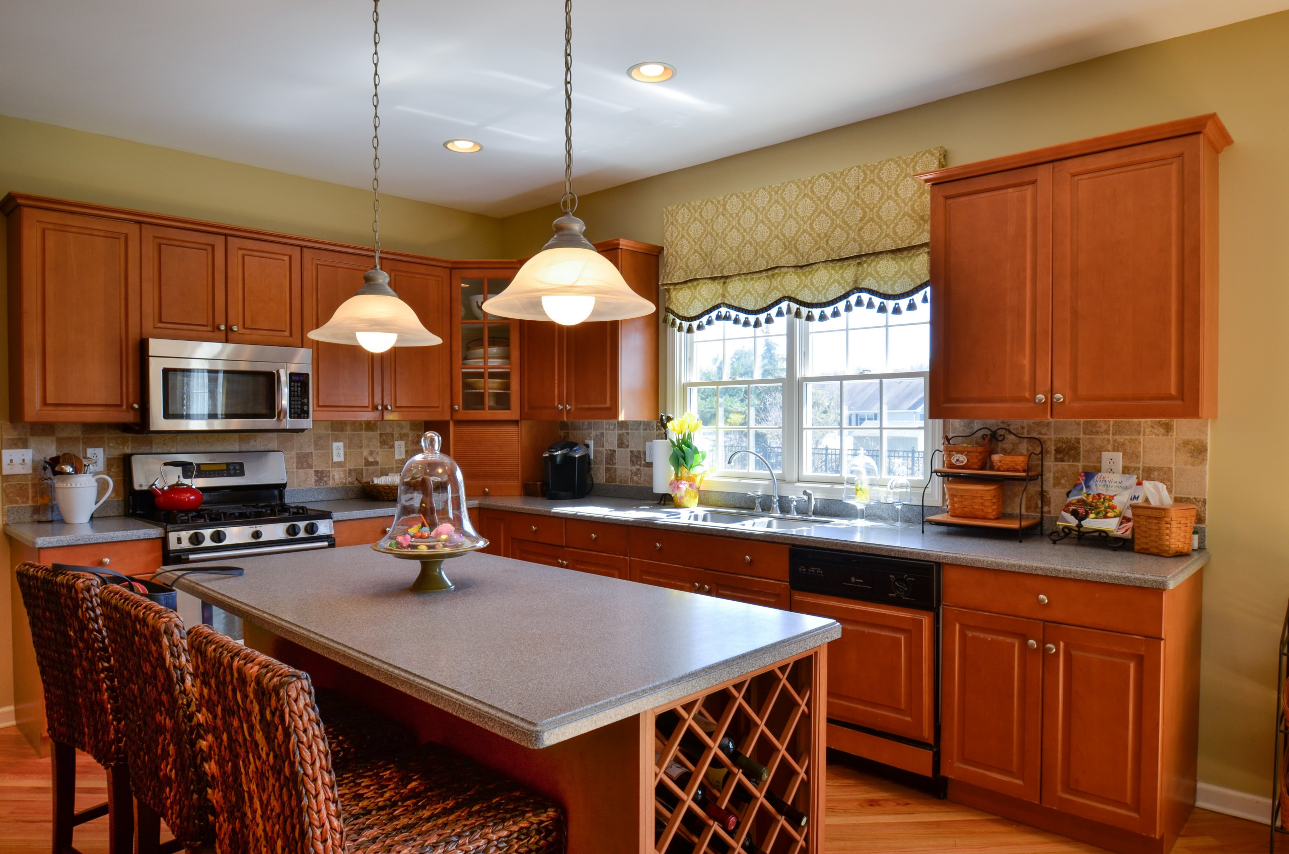 Kitchen with panels and shade with fabric and matching tassel trim.