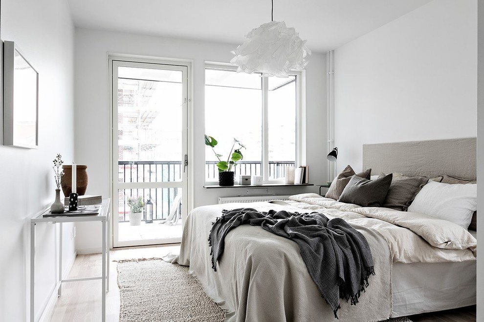 This is an example of a scandinavian bedroom in Stockholm with grey walls, light hardwood floors and beige floor.