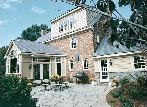 This is an example of a large traditional three-storey brick beige exterior in DC Metro with a gable roof.