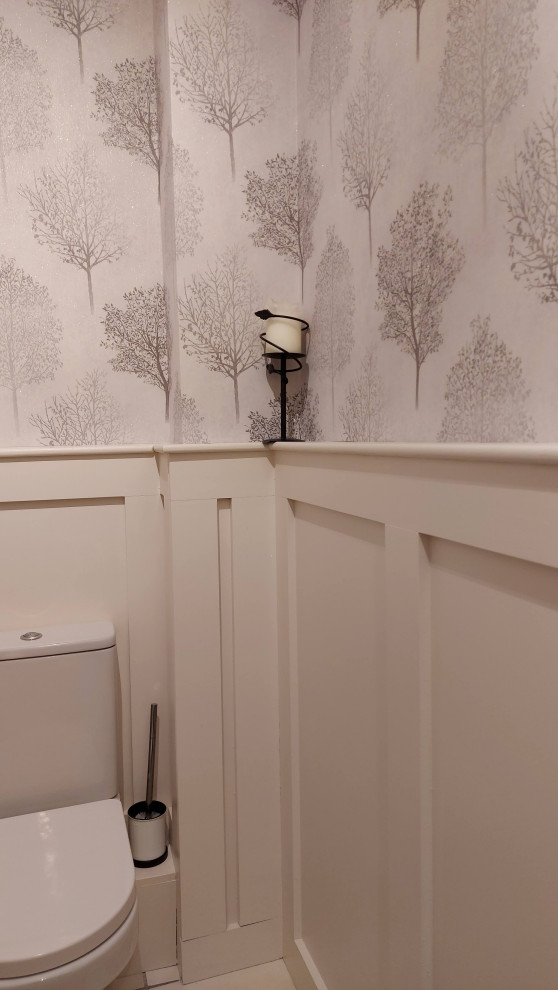 Photo of a small contemporary cloakroom in Dublin with flat-panel cabinets, black cabinets, a one-piece toilet, white tiles, porcelain tiles, multi-coloured walls, ceramic flooring, an integrated sink, white floors, a freestanding vanity unit and wallpapered walls.