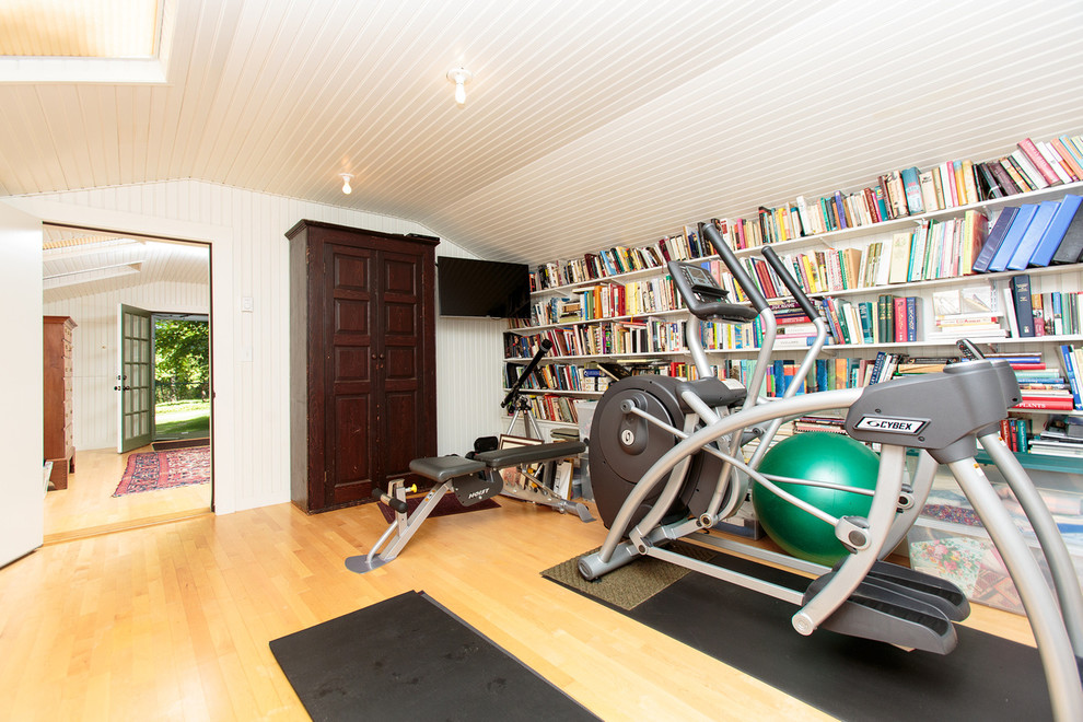 Mid-sized traditional home weight room in Boston with white walls, light hardwood floors and yellow floor.