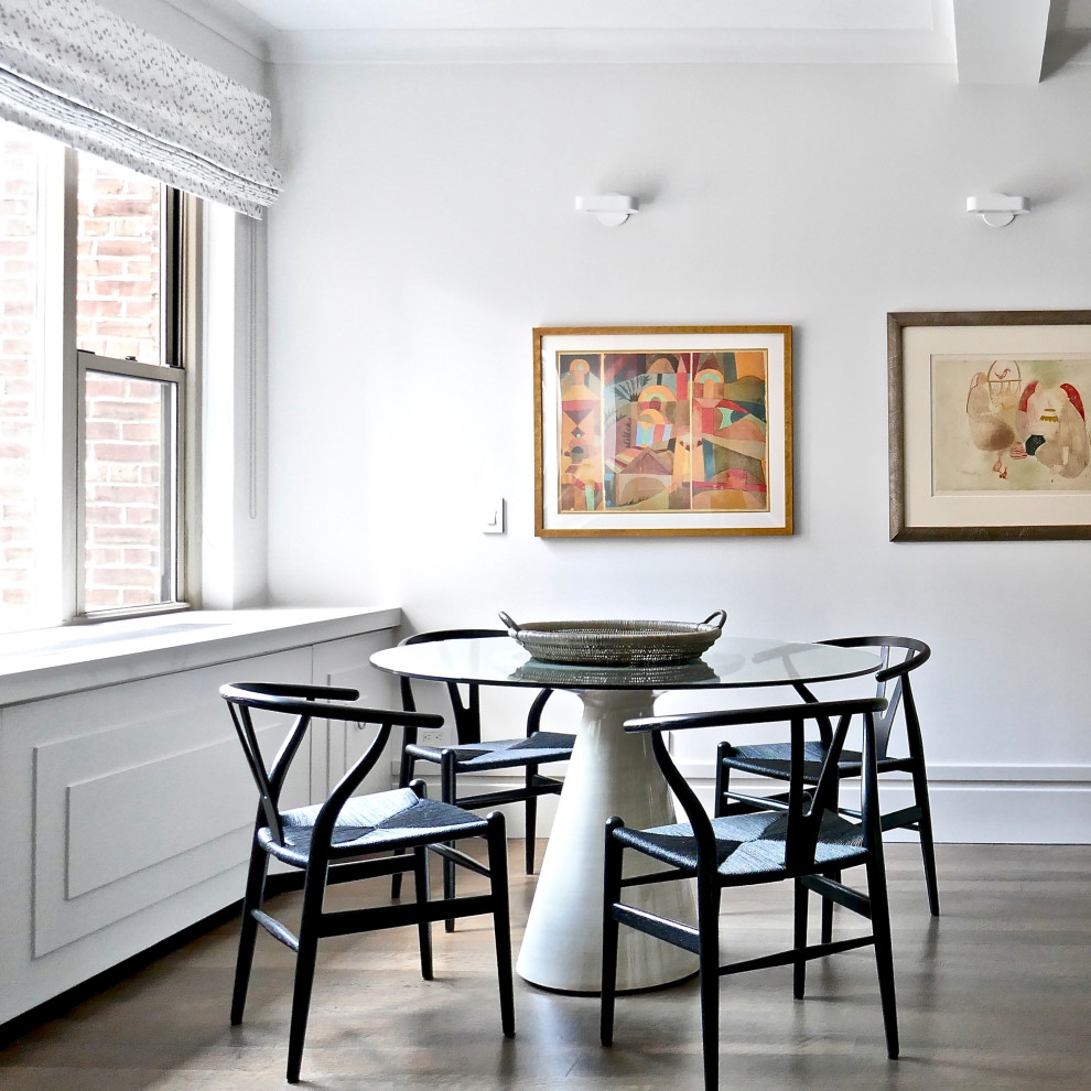 Aménagement d'une salle à manger classique avec une banquette d'angle, un mur blanc, un sol en bois brun, aucune cheminée et un sol marron.