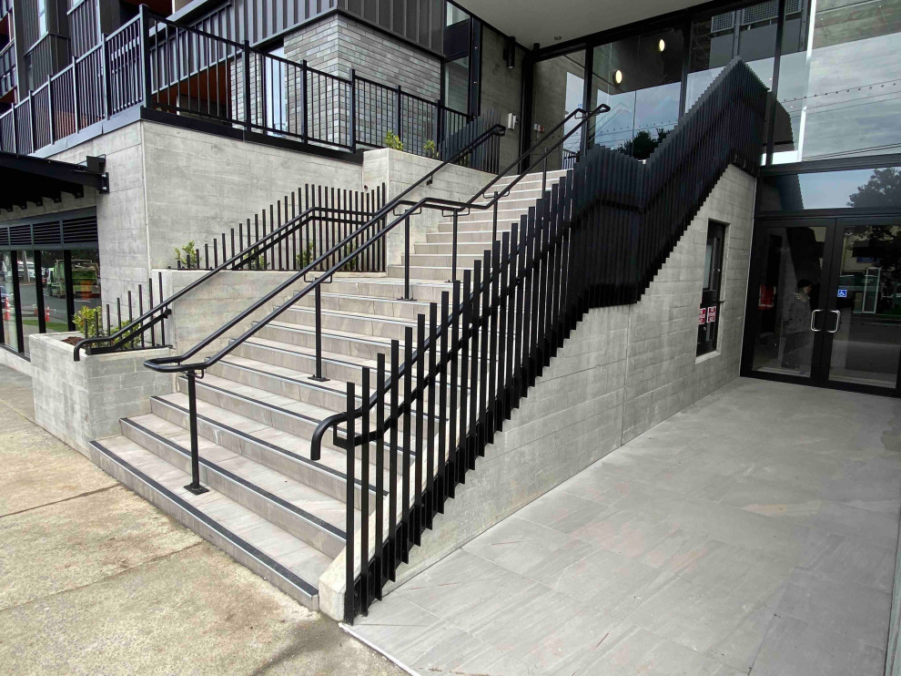 Mid-sized minimalist concrete straight metal railing staircase photo in Auckland with concrete risers