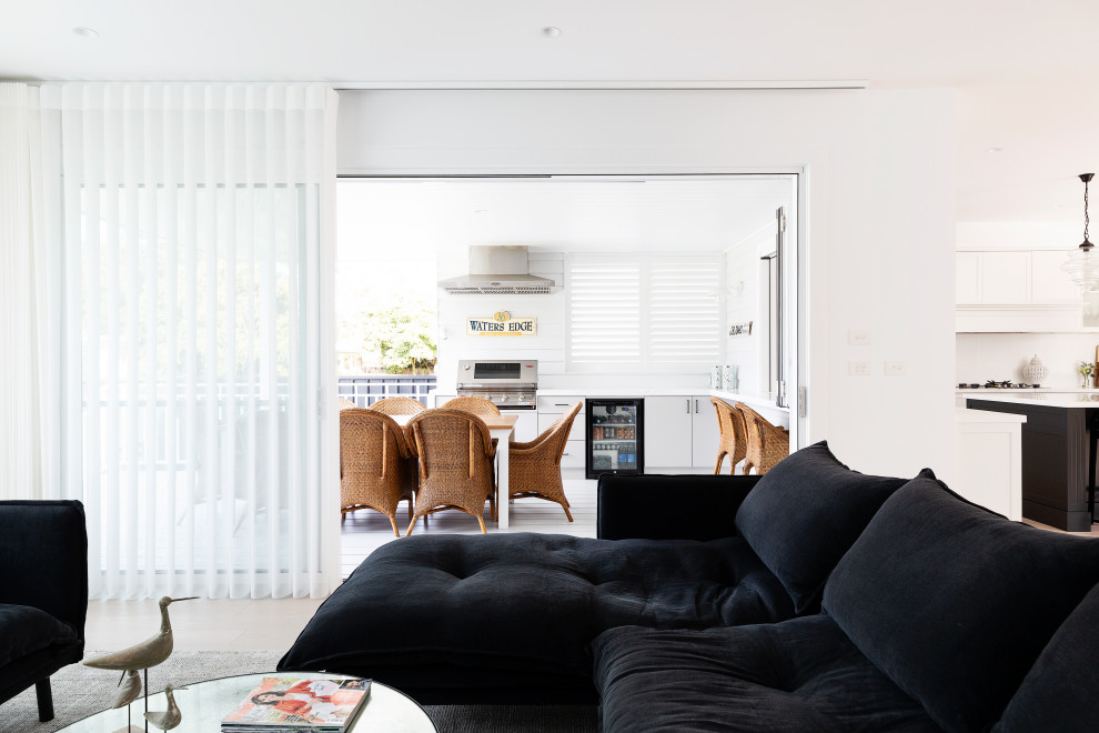 Mittelgroßes, Offenes Maritimes Wohnzimmer mit weißer Wandfarbe, hellem Holzboden, Kamin, Kaminumrandung aus Holz, TV-Wand und beigem Boden in Sydney