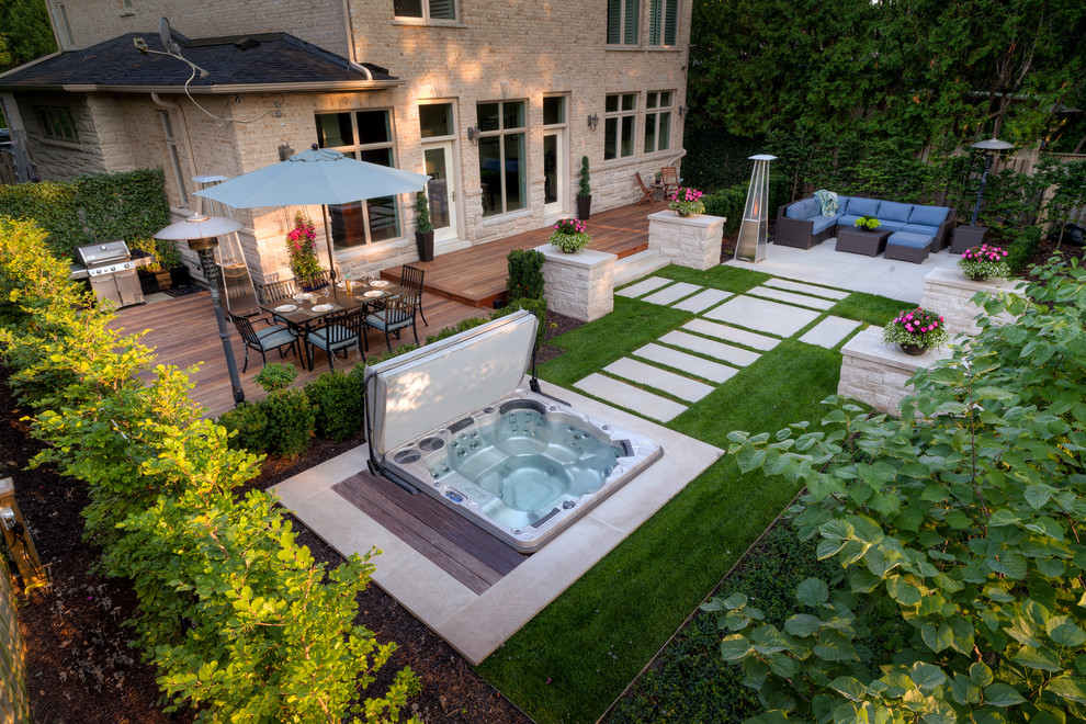 This is an example of a modern backyard pool in Toronto with a hot tub and decking.