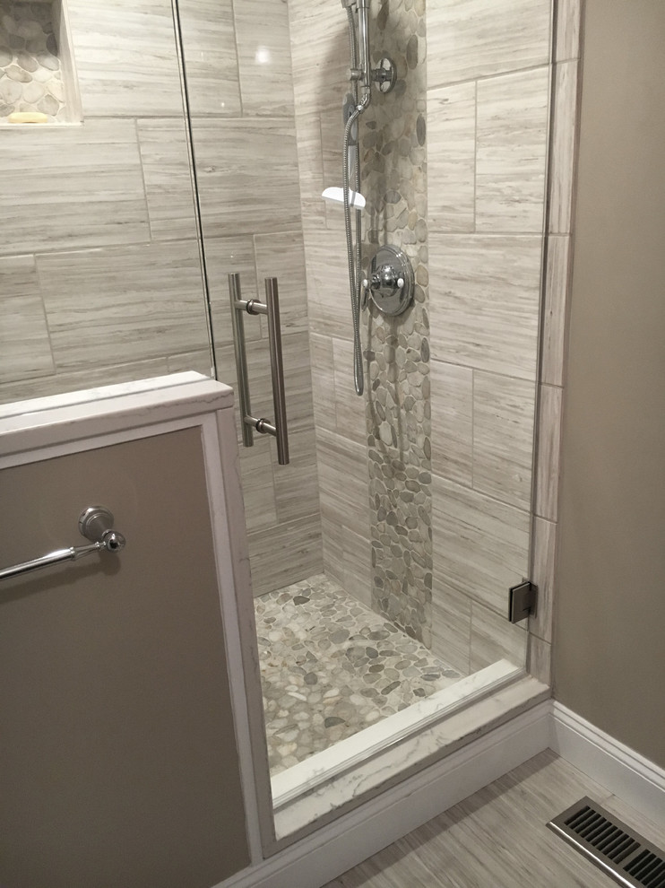 Inspiration for a mid-sized transitional 3/4 bathroom in Other with shaker cabinets, grey cabinets, a corner shower, a one-piece toilet, beige tile, ceramic tile, beige walls, ceramic floors, an undermount sink, engineered quartz benchtops, grey floor, a hinged shower door and white benchtops.