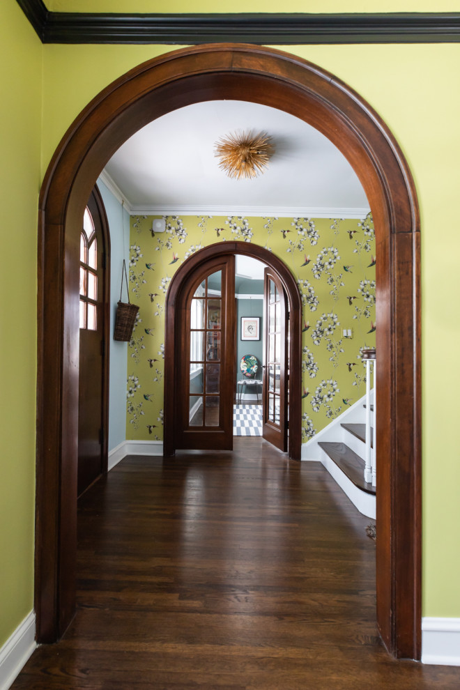 Foto de entrada ecléctica con paredes verdes, suelo de madera oscura, puerta doble, puerta de madera en tonos medios, suelo marrón y papel pintado