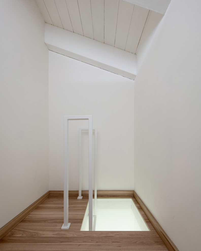 Modelo de recibidores y pasillos escandinavos pequeños con paredes blancas, suelo laminado, suelo marrón y madera