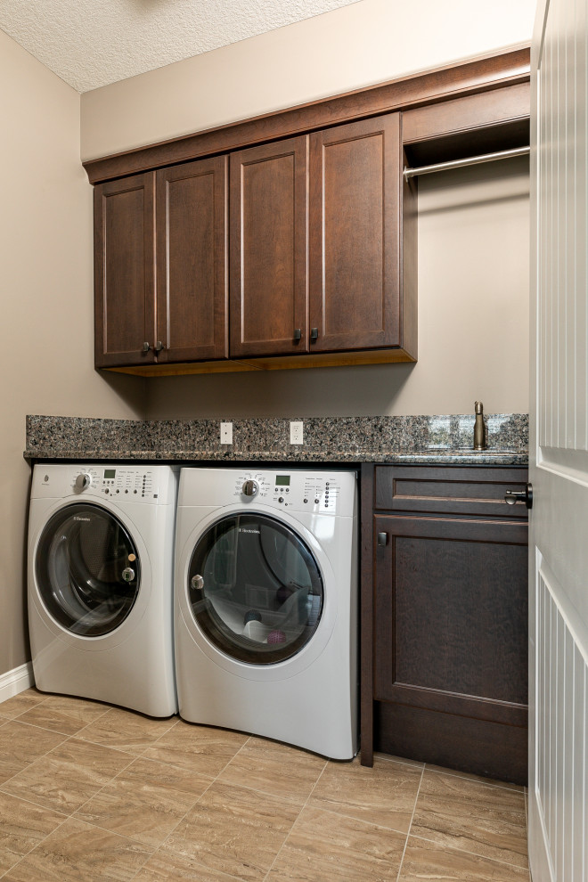 Design ideas for a mid-sized transitional l-shaped laundry room in Other with an undermount sink, flat-panel cabinets, white cabinets, granite benchtops, beige splashback, stone tile splashback, medium hardwood floors, brown floor, beige benchtop and vaulted.